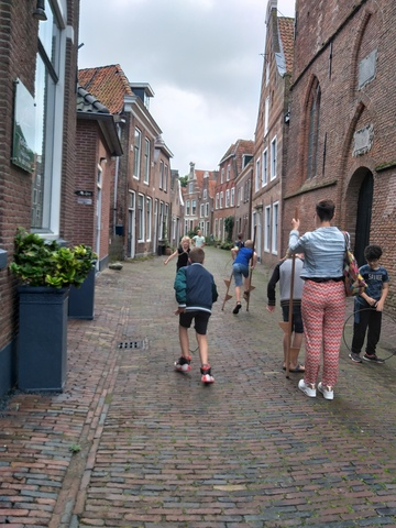 afb 5 weeshuis op stelten lopen in de straat